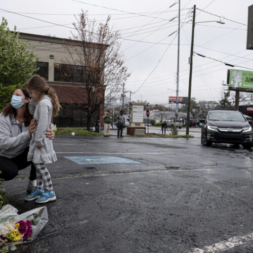 Mallory Rahman and her daughter Zara Rahman, 4, bring flowers to the Gold Spa in Atlanta on Wednesday, the day after eight people were killed at three massage spas in the Atlanta area. Authorities have arrested Robert Aaron Long, 21, in the shootings in Atlanta and Cherokee County, Ga. CREDIT: Ben Gray/AP