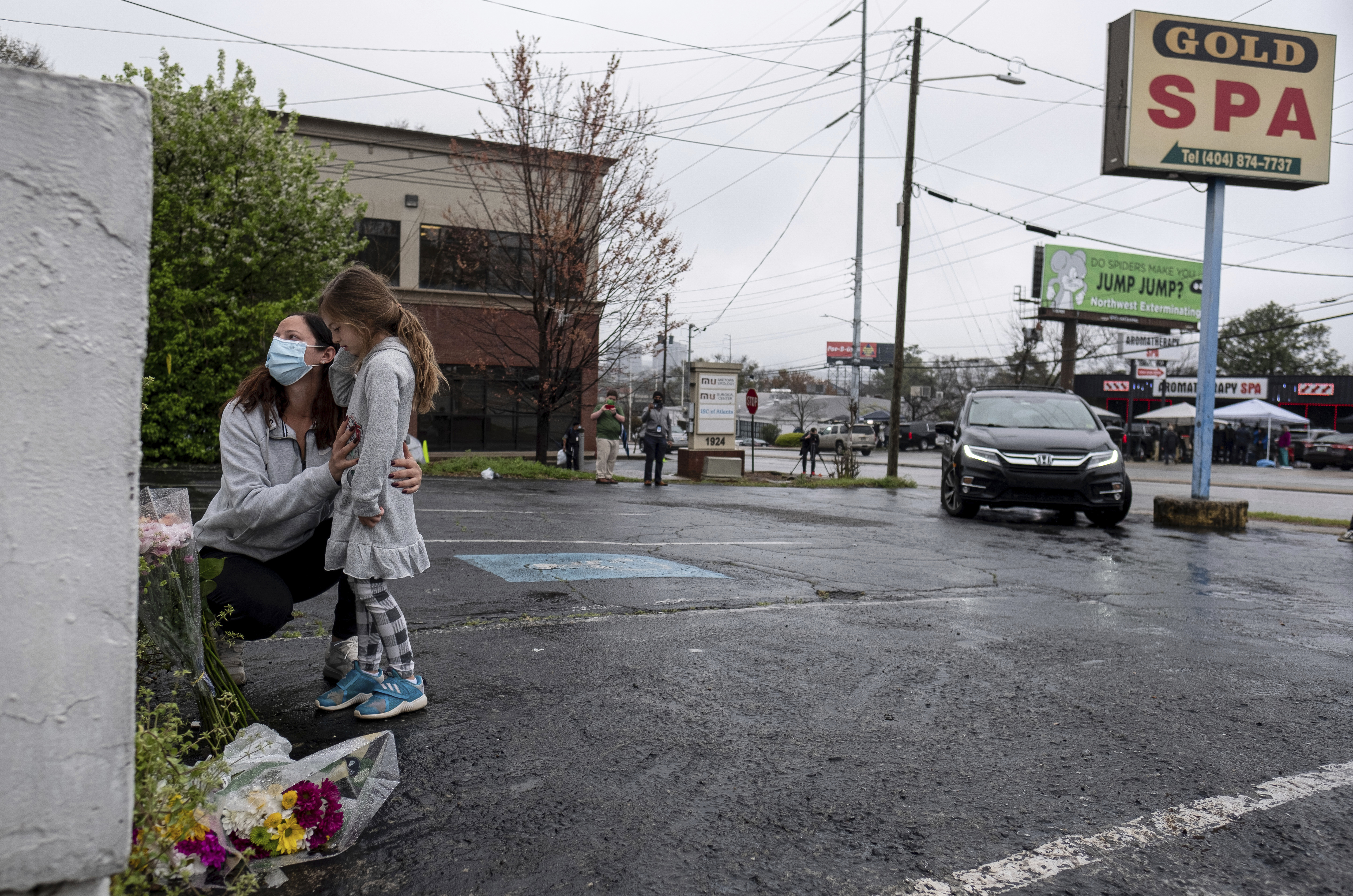 Mallory Rahman and her daughter Zara Rahman, 4, bring flowers to the Gold Spa in Atlanta on Wednesday, the day after eight people were killed at three massage spas in the Atlanta area. Authorities have arrested Robert Aaron Long, 21, in the shootings in Atlanta and Cherokee County, Ga. CREDIT: Ben Gray/AP
