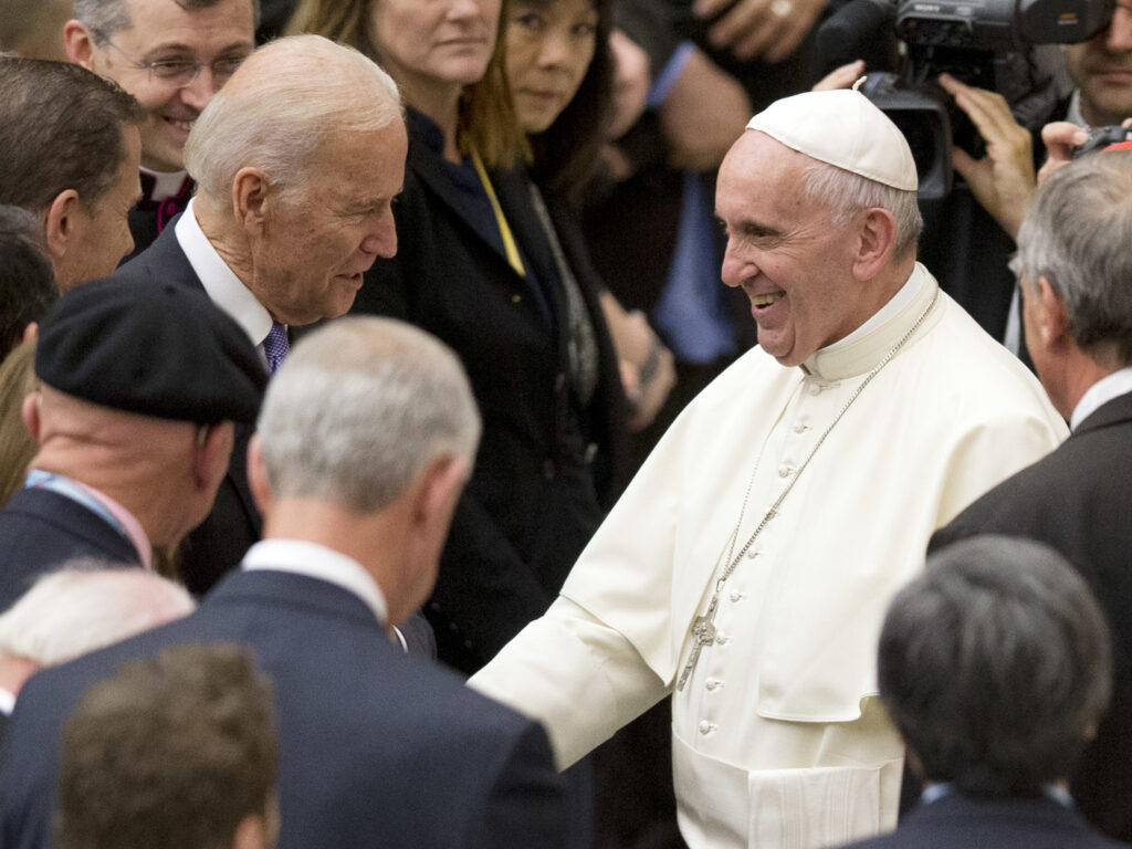 Pope Francis shakes hands with Joe Biden, then vice president, at the Vatican, in 2016. Andrew Medichini/AP