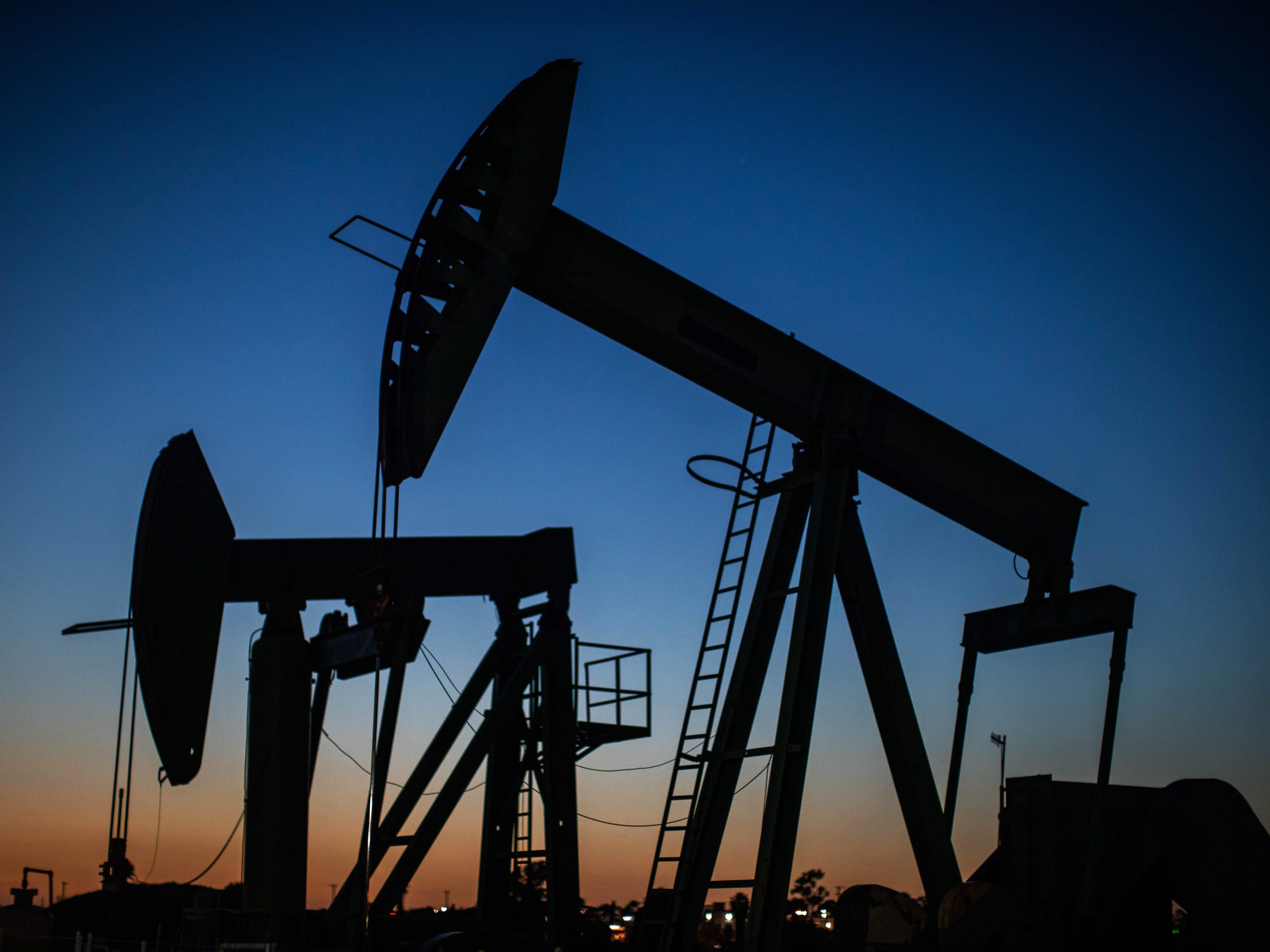 Oil pump jacks operate at dusk in Long Beach, Calif., on April 21, 2020. After getting burned by the oil industry's previous boom-and-bust cycles, Wall Street now wants energy companies to pump less crude, not more. Apu Gomes/AFP via Getty Images