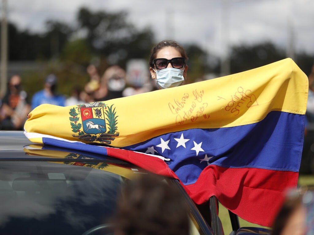 A Joe Biden supporter with a Venezuelan flag cheers during a Biden campaign event at Camping World Stadium on October 27, 2020 in Orlando, Florida. CREDIT: Octavio Jones/Getty Images