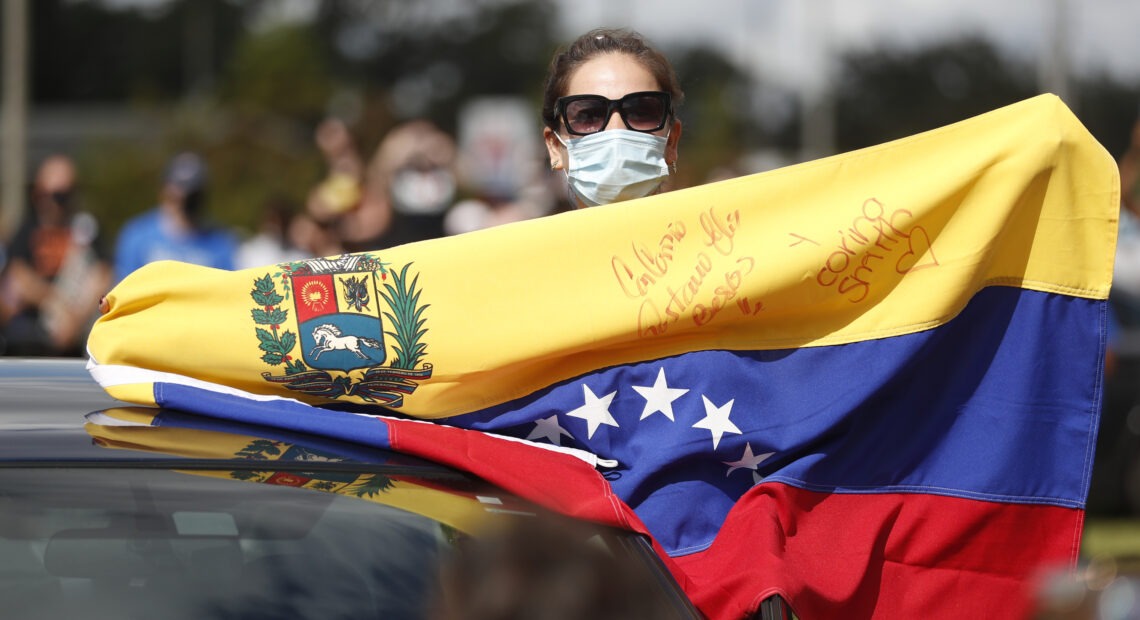 A Joe Biden supporter with a Venezuelan flag cheers during a Biden campaign event at Camping World Stadium on October 27, 2020 in Orlando, Florida. CREDIT: Octavio Jones/Getty Images