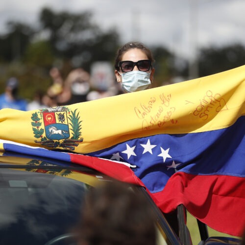 A Joe Biden supporter with a Venezuelan flag cheers during a Biden campaign event at Camping World Stadium on October 27, 2020 in Orlando, Florida. CREDIT: Octavio Jones/Getty Images