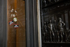 Stickers reading "Fck Antifa" are stuck on a broken window at the U.S. Capitol after the building was breached by rioters on Jan. 6. Graeme Sloan/Bloomberg via Getty Images