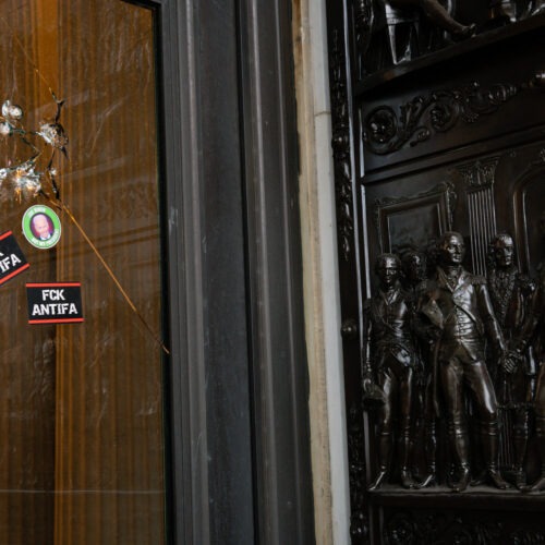 Stickers reading "Fck Antifa" are stuck on a broken window at the U.S. Capitol after the building was breached by rioters on Jan. 6. Graeme Sloan/Bloomberg via Getty Images