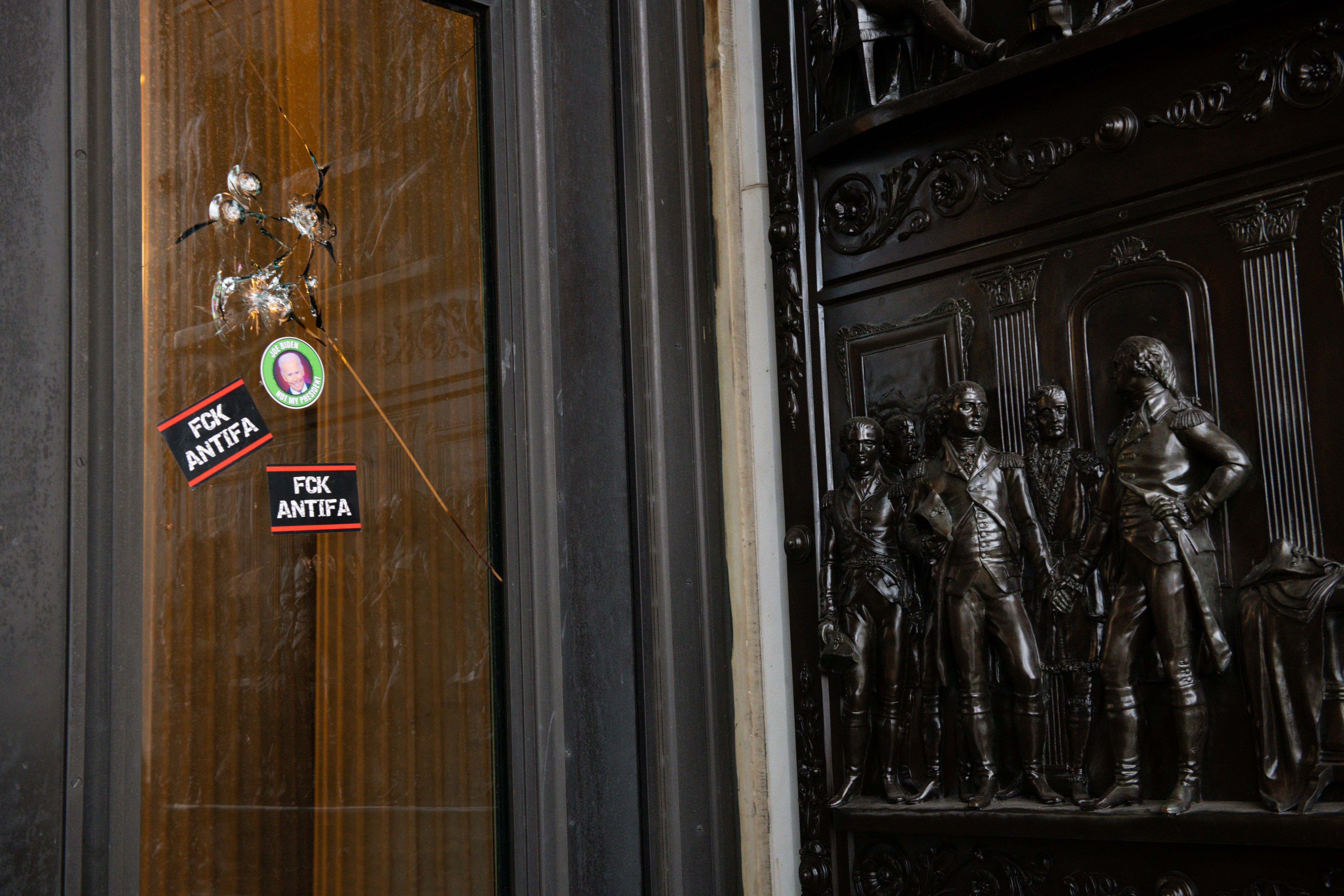 Stickers reading "Fck Antifa" are stuck on a broken window at the U.S. Capitol after the building was breached by rioters on Jan. 6. Graeme Sloan/Bloomberg via Getty Images