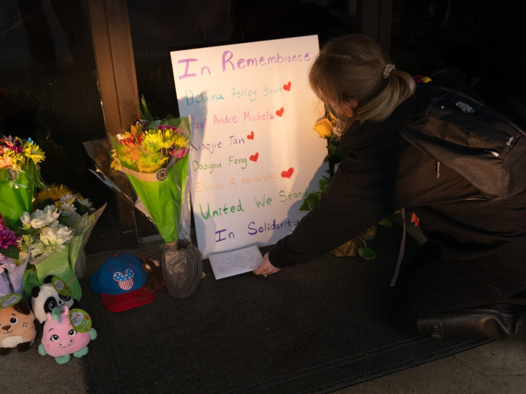 Shelby Swan places a sign outside Youngs Asian Massage, where four people were shot and killed this week in Acworth, Ga. Another four people were fatally shot at two massage businesses in Atlanta, but authorities have not released their names. CREDIT: Elijah Nouvelage/Getty Images