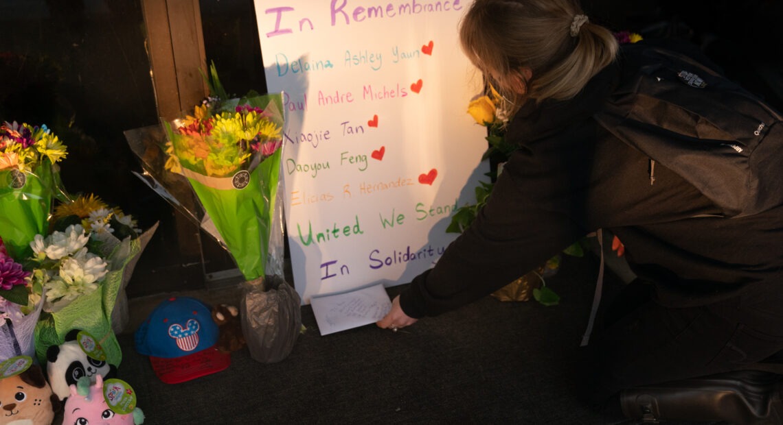 Shelby Swan places a sign outside Youngs Asian Massage, where four people were shot and killed this week in Acworth, Ga. Another four people were fatally shot at two massage businesses in Atlanta, but authorities have not released their names. CREDIT: Elijah Nouvelage/Getty Images