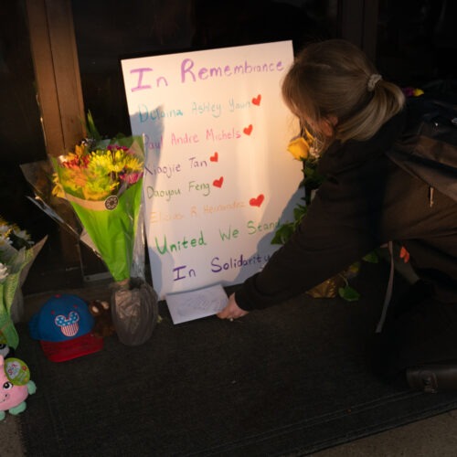 Shelby Swan places a sign outside Youngs Asian Massage, where four people were shot and killed this week in Acworth, Ga. Another four people were fatally shot at two massage businesses in Atlanta, but authorities have not released their names. CREDIT: Elijah Nouvelage/Getty Images