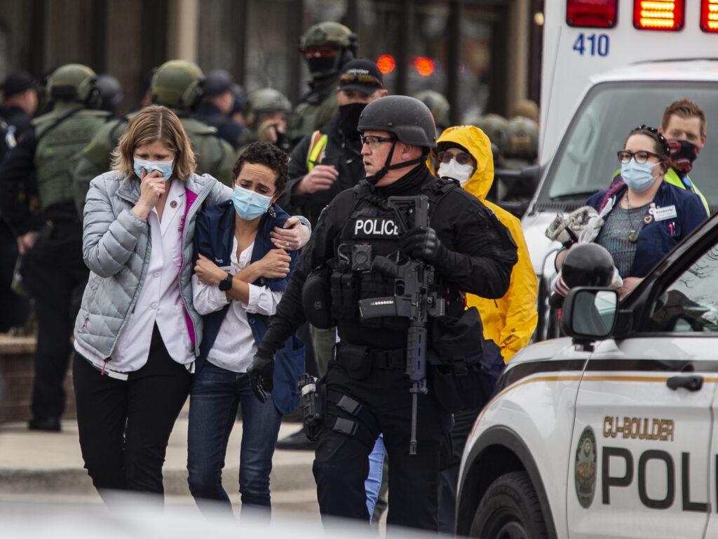 Healthcare workers walk out of a King Sooper's Grocery store after a gunman opened fire on Monday in Boulder, Colo. CREDIT: Chet Strange/Getty Images