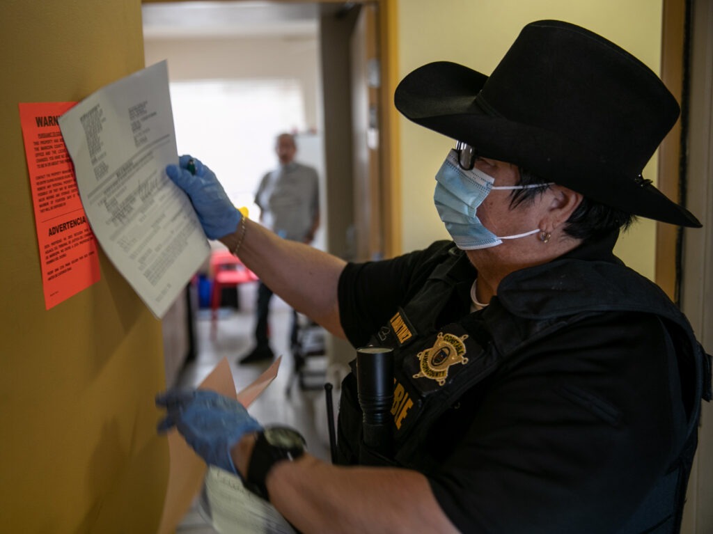 Constable placing eviction notice on door in Texas