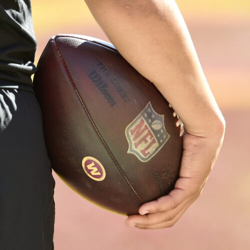 person holding a football with NFL logo