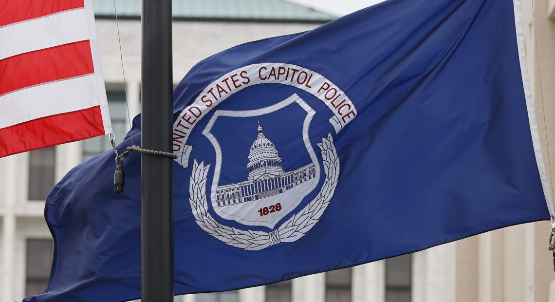 The U.S. and U.S. Capitol Police flags were flown at half-staff after the death of officer Brian Sicknick. On Sunday, the FBI arrested two men who are accused of spraying chemicals on Sicknick and others. CREDIT: Chip Somodevilla/Getty Images
