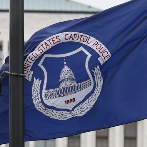 The U.S. and U.S. Capitol Police flags were flown at half-staff after the death of officer Brian Sicknick. On Sunday, the FBI arrested two men who are accused of spraying chemicals on Sicknick and others. CREDIT: Chip Somodevilla/Getty Images