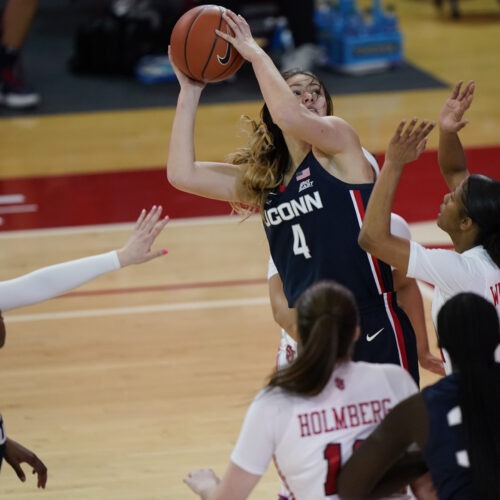 Connecticut guard Saylor Poffenbarger (4) is defended by St. John's guard Danaijah Williams (24) and forward Cecilia Holmberg (11) during the fourth quarter of an NCAA college basketball game in New York last month. The women's NCAA championship begins Sunday. CREDIT: Kathy Willens/AP