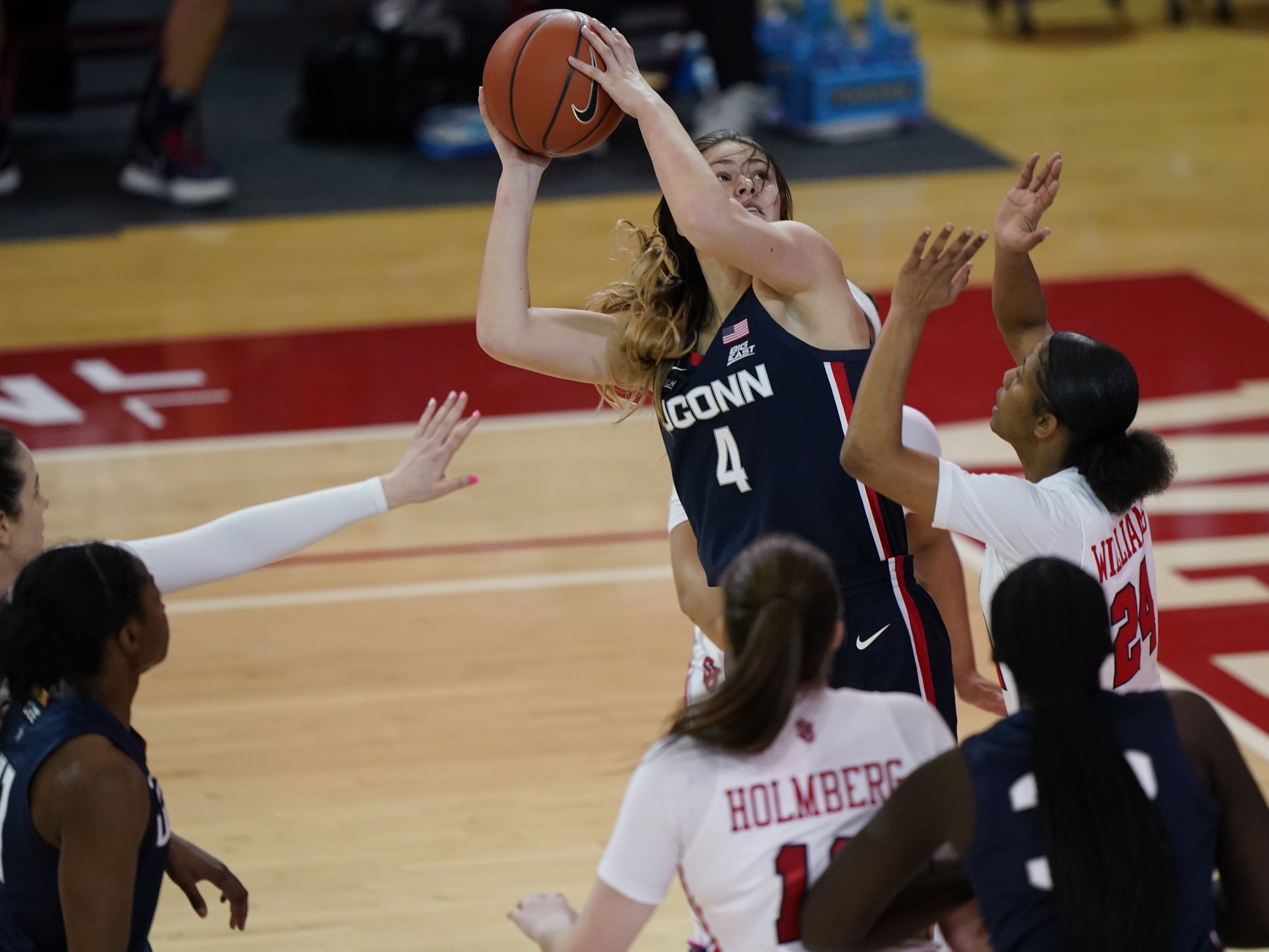 Connecticut guard Saylor Poffenbarger (4) is defended by St. John's guard Danaijah Williams (24) and forward Cecilia Holmberg (11) during the fourth quarter of an NCAA college basketball game in New York last month. The women's NCAA championship begins Sunday. CREDIT: Kathy Willens/AP