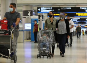With precautions such as mask-wearing in place, experts predict travel is among the activities that may become safer by this summer. CREDIT: Joe Raedle/Getty Images