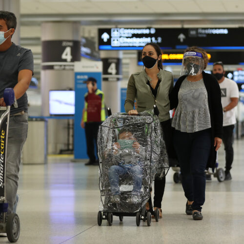 With precautions such as mask-wearing in place, experts predict travel is among the activities that may become safer by this summer. CREDIT: Joe Raedle/Getty Images