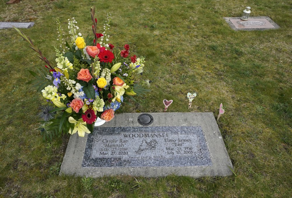 Flowers from her memorial service mark the headstone shared by Carole Rae Woodmansee and her husband Jim (who died in 2003), March 27, 2021, at Union Cemetery in Sedro-Woolley, Wash. CREDIT: Ted S. Warren/AP