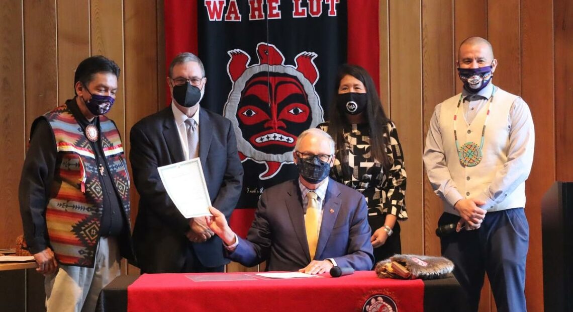 Washington Gov. Jay Inslee signed the Billy Frank Jr. statue bill into law at Wa He Lut Indian School on Wednesday. Looking on, from left, were Nisqually Tribal Chairman Ken Choke, Lt. Gov. Denny Heck, state Rep. Debra Lekanoff and tribal councilman Willie Frank III. CREDIT: Tom Banse/N3