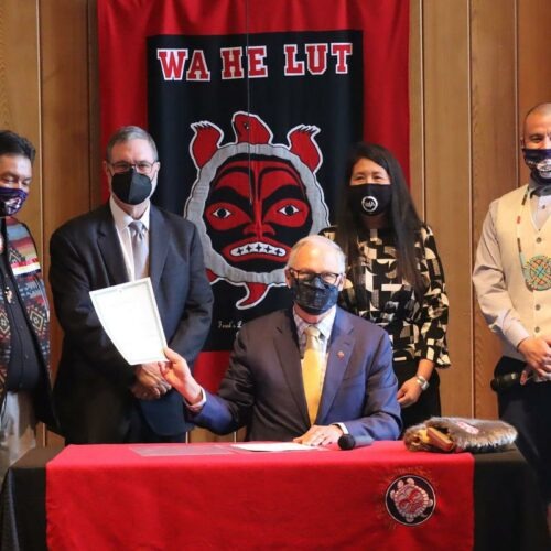 Washington Gov. Jay Inslee signed the Billy Frank Jr. statue bill into law at Wa He Lut Indian School on Wednesday. Looking on, from left, were Nisqually Tribal Chairman Ken Choke, Lt. Gov. Denny Heck, state Rep. Debra Lekanoff and tribal councilman Willie Frank III. CREDIT: Tom Banse/N3