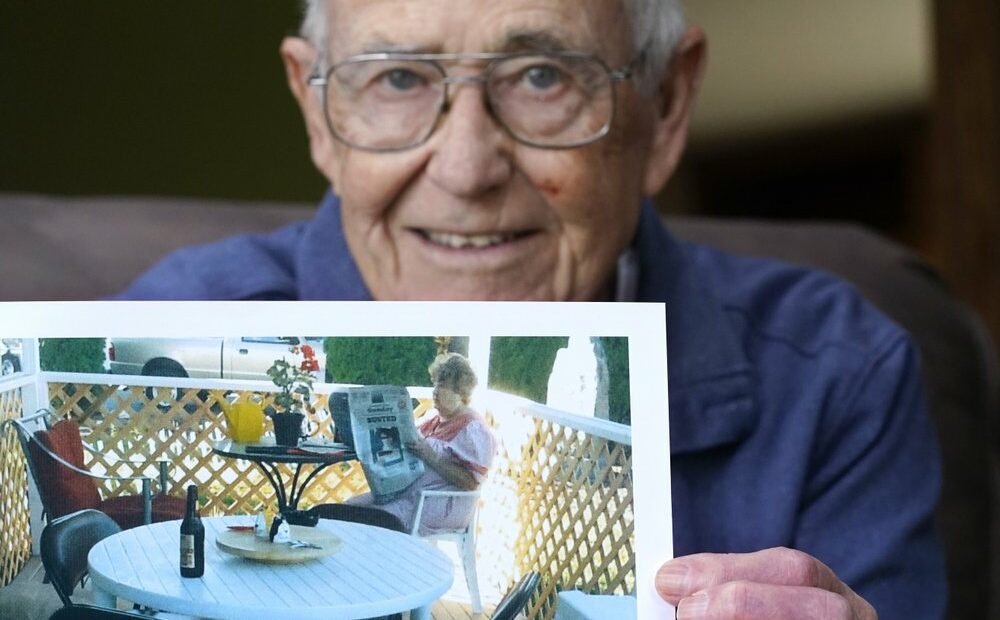 Victor Hamilton displays a photo of his late wife, Nancy "Nicki" Hamilton, who died about a year earlier after contracting COVID-19 at a choir practice, Thursday, April 8, 2021, at his home in Mount Vernon, Wash. The choir practice in sickened 53 people and killed two, becoming one of the first known COVID-19 superspreader events in the United States. CREDIT: Elaine Thompson/AP