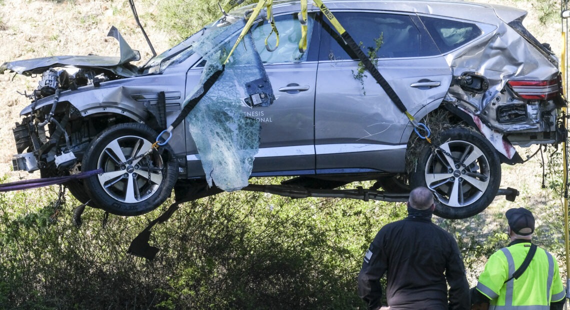 A crane is used to lift a vehicle driven by golfer Tiger Woods following a rollover accident in February in the Rancho Palos Verdes suburb of Los Angeles. CREDIT: Ringo H.W. Chiu/AP