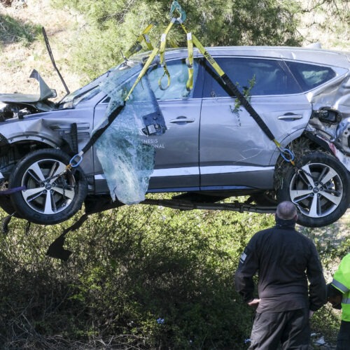 A crane is used to lift a vehicle driven by golfer Tiger Woods following a rollover accident in February in the Rancho Palos Verdes suburb of Los Angeles. CREDIT: Ringo H.W. Chiu/AP