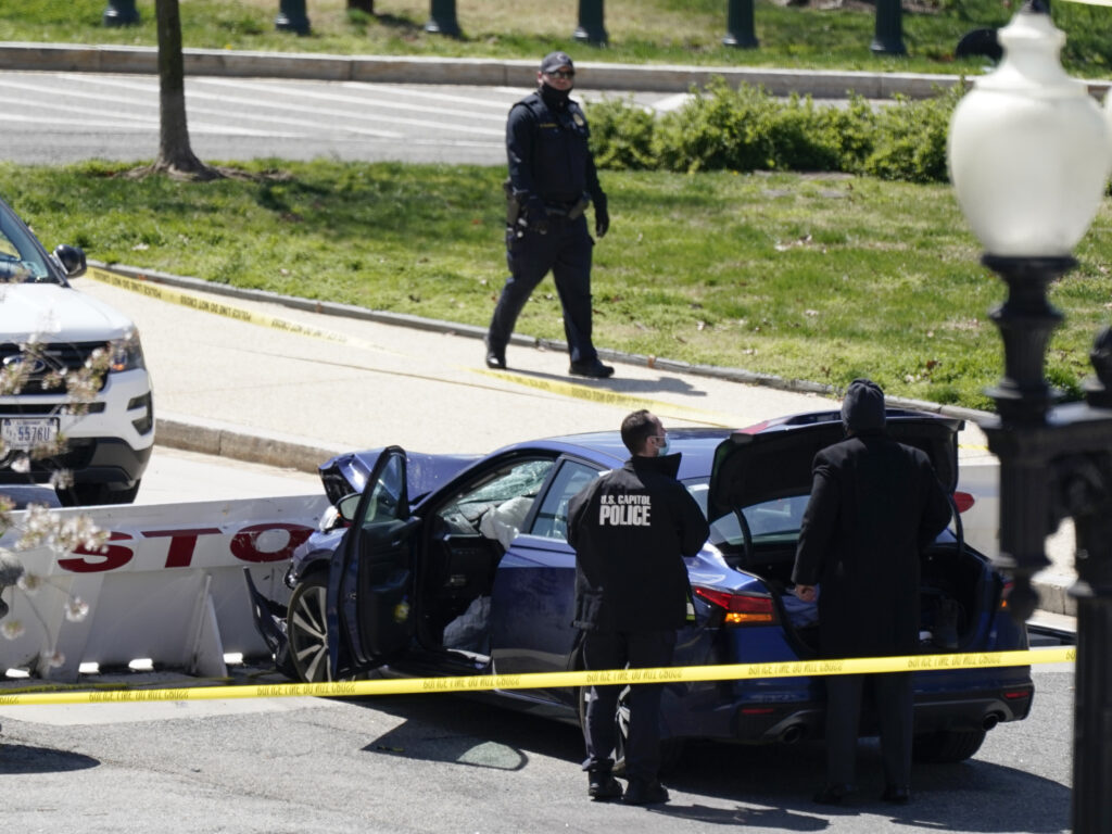 Capitol Police officers stand near a car that crashed into a barrier Friday on Capitol Hill. CREDIT: J. Scott Applewhite/AP