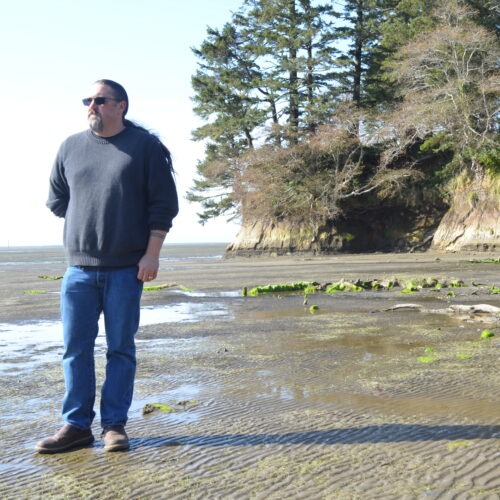 Tony Johnson is chair of the Chinook Indian Nation, a federally unrecognized tribe. He stands on a Willapa Bay, Wash., beach, where he got married and not far from where his ancestors lived. CREDIT: Eilis O'Neill/KUOW