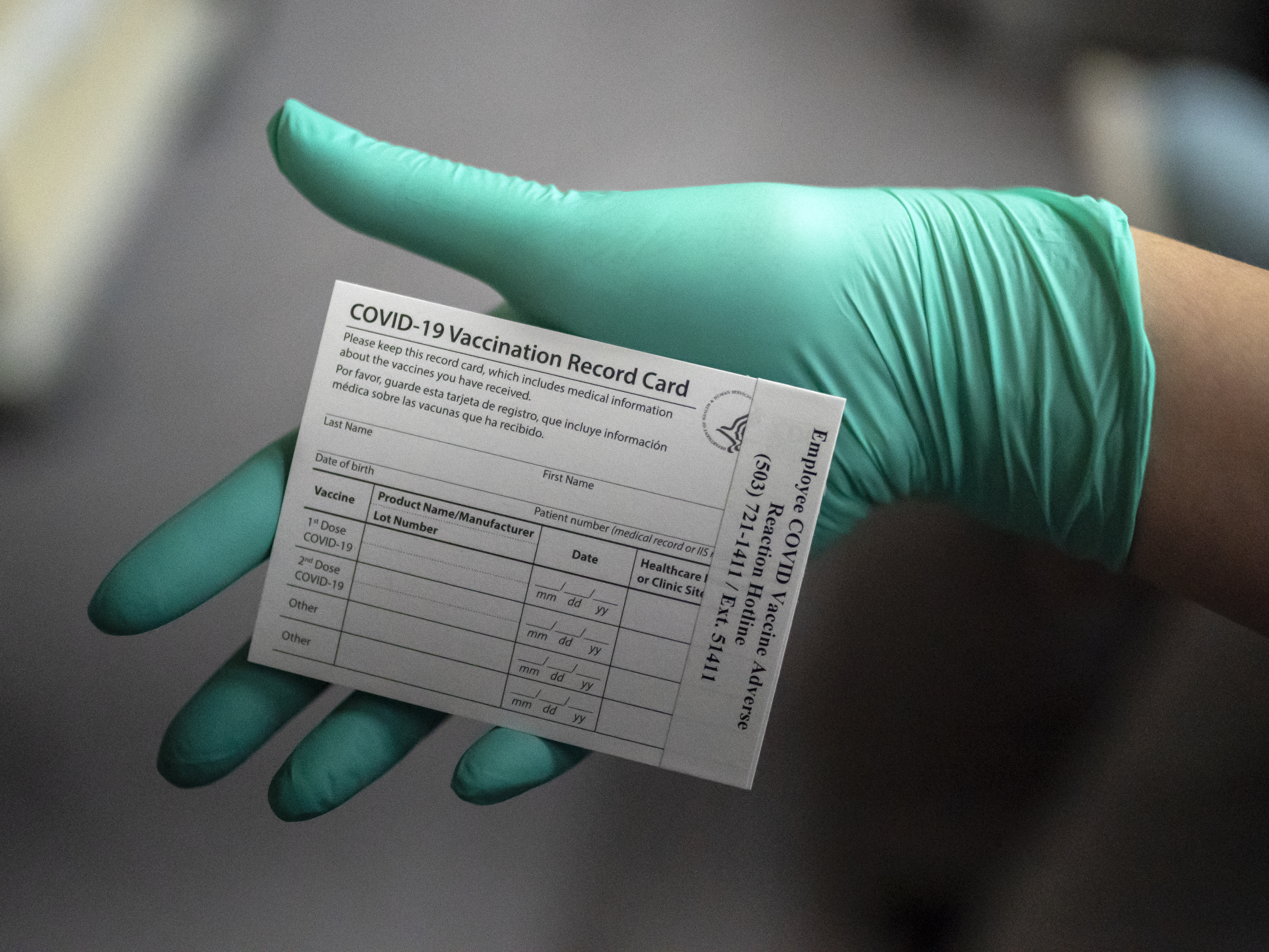 A healthcare worker displays a COVID-19 vaccine record card at the Portland Veterans Affairs Medical Center in December. CREDIT: Nathan Howard/Getty Images