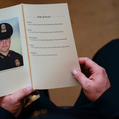 A U.S. Capitol Police officer holds a program as Brian Sicknick lays in honor in the Capitol Rotunda on Feb. 3. A medical examiner has determined that Officer Sicknick died of natural causes following the Jan. 6 insurrection. Demetrius Freeman/Pool/AFP via Getty Images