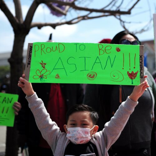 A boy holding a sign takes part in a Stop Asian Hate rally in Oakland, Calif.