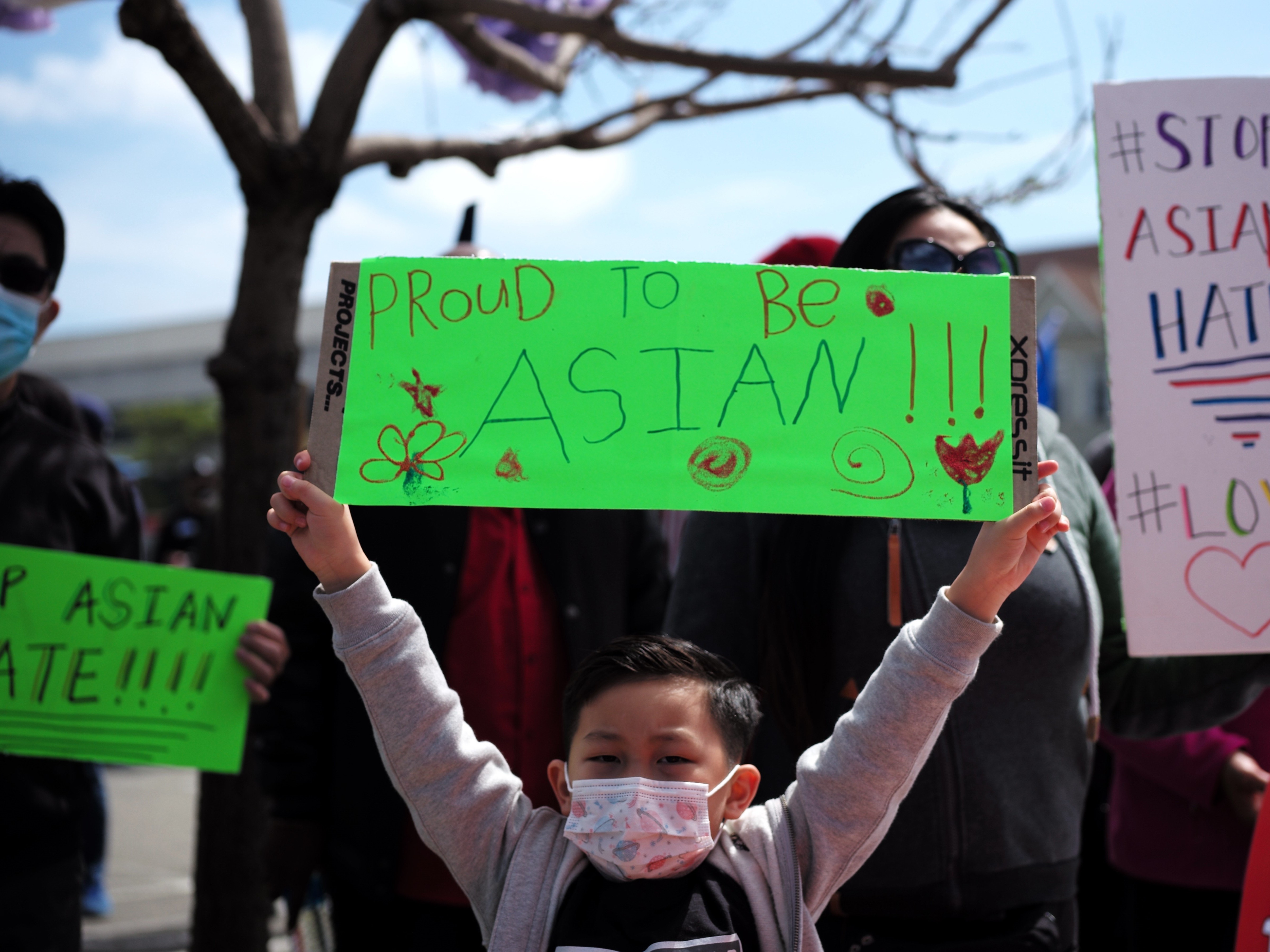 A boy holding a sign takes part in a Stop Asian Hate rally in Oakland, Calif.