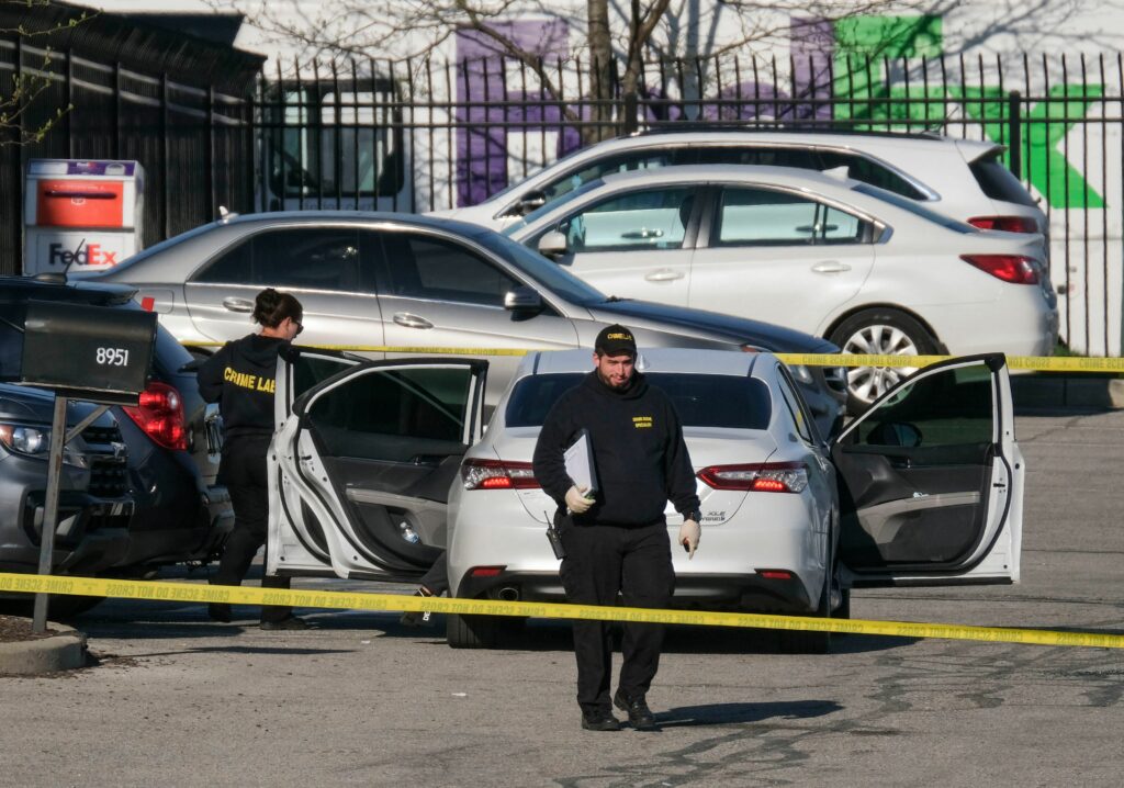 Crime scene investigators walk through the parking lot of a FedEx facility in Indianapolis on Friday. A gunman killed at least eight people and injured several others. CREDIT: Jeff Dean/AFP via Getty Images