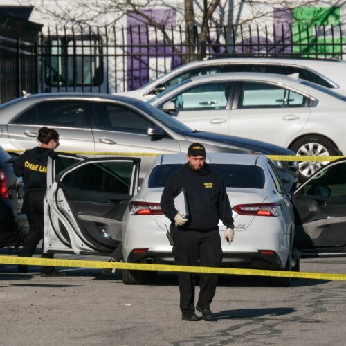 Crime scene investigators walk through the parking lot of a FedEx facility in Indianapolis on Friday. A gunman killed at least eight people and injured several others. CREDIT: Jeff Dean/AFP via Getty Images