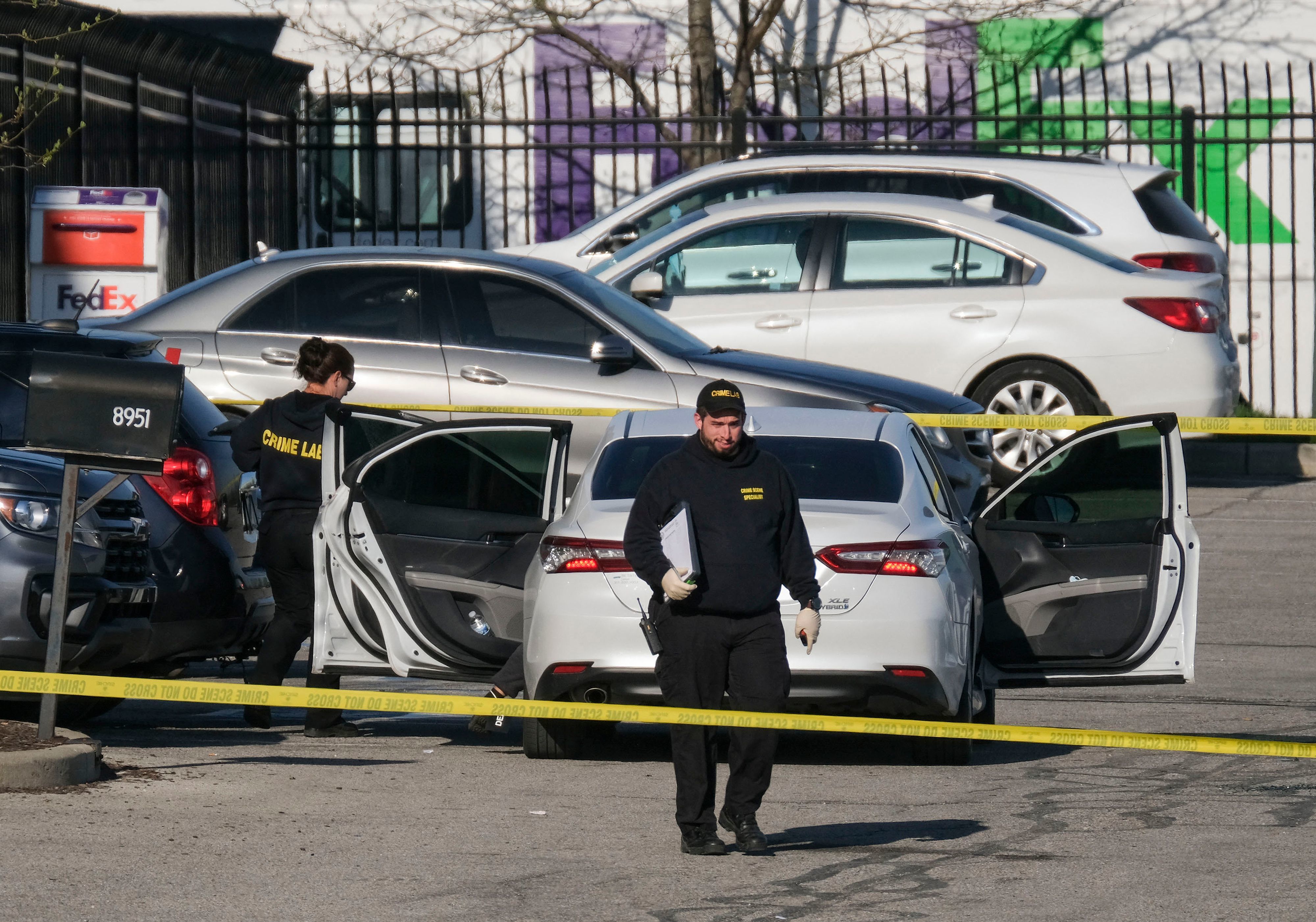 Crime scene investigators walk through the parking lot of a FedEx facility in Indianapolis on Friday. A gunman killed at least eight people and injured several others. CREDIT: Jeff Dean/AFP via Getty Images