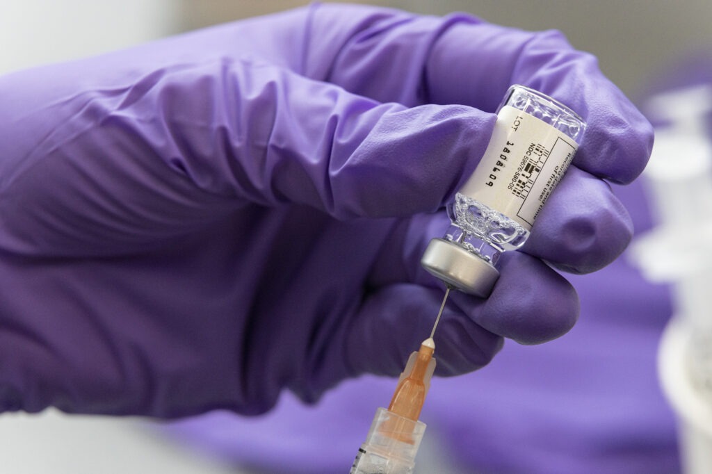 syringe going into a vial of COVID-19 vaccine 