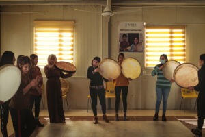 Rana Sulaiman Halo (center), performs with a traditional daf drum with the Ashti (Peace) Choir. Emily Garthwaite/INSTITUTE for NPR