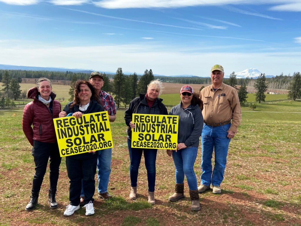 Members of C.E.A.S.E – Citizens Educated About Solar Energy – gather on Amy Hanson’s land (center right). Hanson and her husband, Russ, hoped to build their retirement home here, but stopped their plans once they learned their property could be hemmed in on three sides by solar panels. CREDIT: Courtney Flatt/NWPB