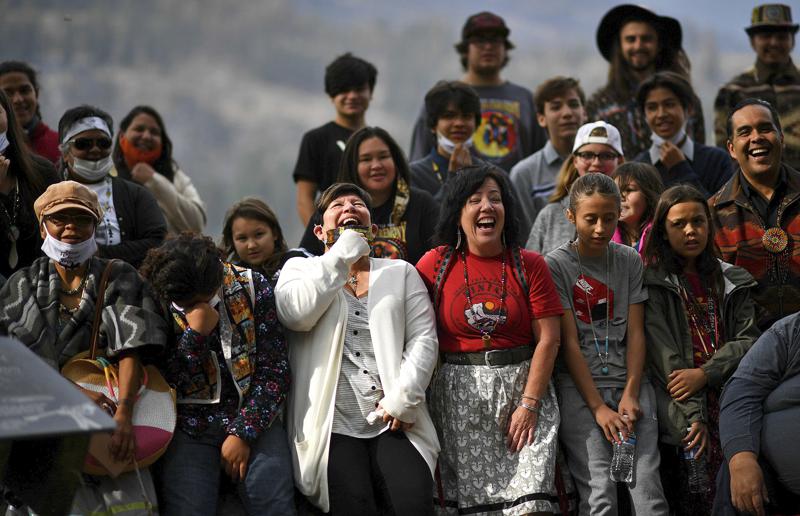 Linda Desautel, center in white, looks skyward and cheers with friends and Colville Confederated Tribe members as they rally in support of her husband Rick Desautel, whose case in the Canadian Supreme court arguing for the Sinixt peoples' right to hunt traditional lands in Canada was first heard, on Thursday, Oct. 8, 2020, near Kettle Falls, Wash. It's been 50 years since the Confederated Tribes of the Colville Reservation voted against termination, effectively ending the federal government's experiment in abrogating treaties, eliminating funding and "freeing the Indians" from the Bureau of Indian Affairs. More than 100 tribes were terminated by the United States — but not one after the 12 bands that make up the reservation in Washington state crushed the idea at the ballot box. CREDIT: Tyler Tjomsland/The Spokesman-Review via AP