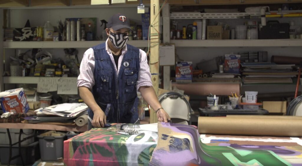 Artist Peyton Scott Russell prepares a canvas painting at his studio in Minneapolis. CREDIT: Sam Lane/PBS NewsHour