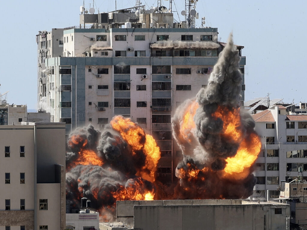 A ball of fire erupts from a building housing various international media, including The Associated Press, after an Israeli airstrike on Saturday in Gaza City. AP staffers and other tenants safely evacuated the building after the Israeli military telephoned a warning that the strike was imminent. CREDIT: Mahmud Hams/AP