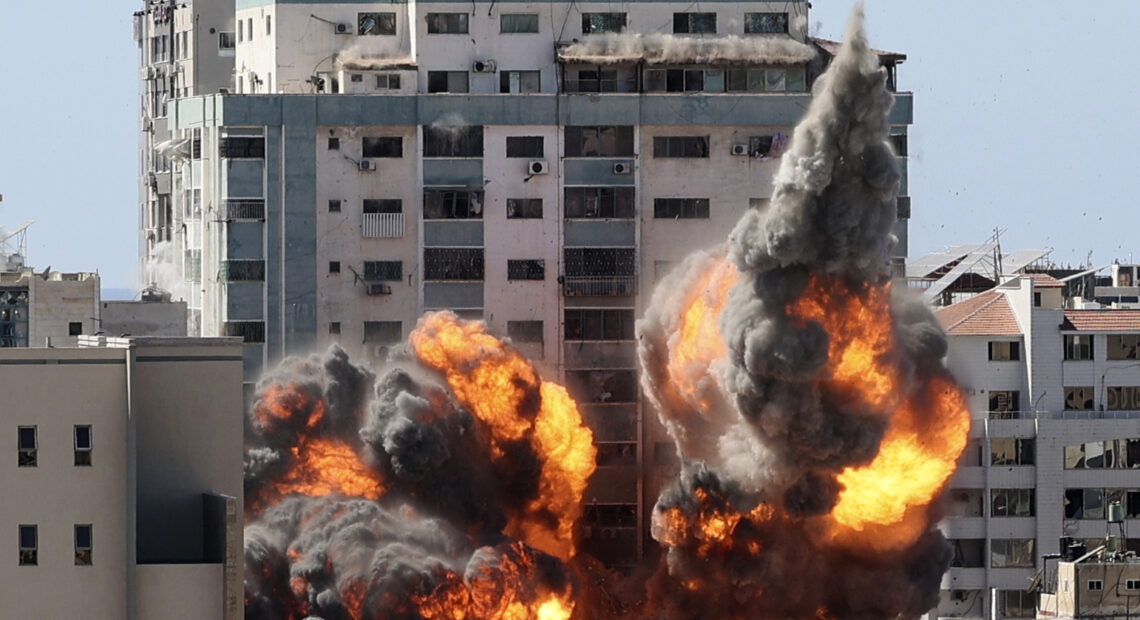 A ball of fire erupts from a building housing various international media, including The Associated Press, after an Israeli airstrike on Saturday in Gaza City. AP staffers and other tenants safely evacuated the building after the Israeli military telephoned a warning that the strike was imminent. CREDIT: Mahmud Hams/AP