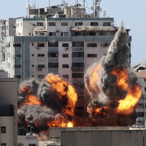 A ball of fire erupts from a building housing various international media, including The Associated Press, after an Israeli airstrike on Saturday in Gaza City. AP staffers and other tenants safely evacuated the building after the Israeli military telephoned a warning that the strike was imminent. CREDIT: Mahmud Hams/AP