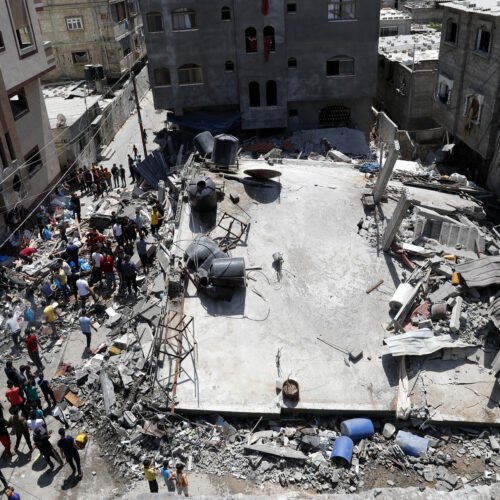 People gather near the rubble of a residential building hit by Israeli airstrikes Thursday in Beit Lahiya, Gaza Strip. CREDIT: Adel Hana/AP