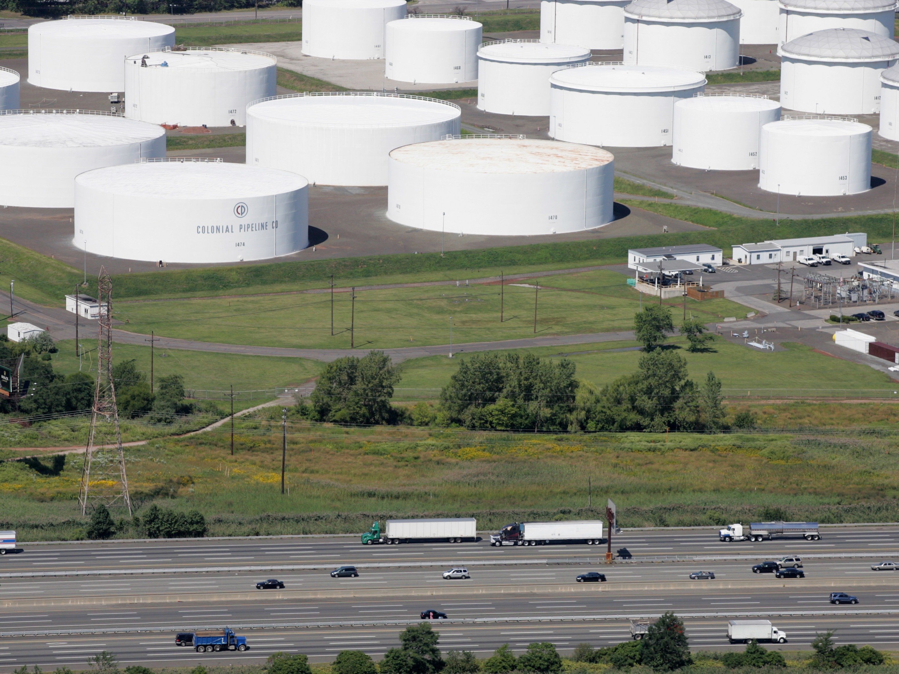 Traffic on I-95 passes oil storage tanks owned by the Colonial Pipeline Co. in Linden, N.J. An cybersecurity attack has shut down Colonial Pipeline, a major transporter of gasoline along the East Coast. CREDIT: Mark Lennihan/AP