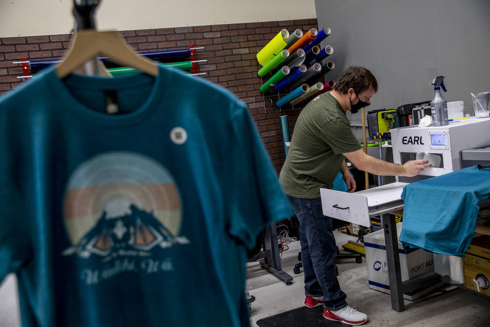 Rob Lewis, co-founder of R Digital Design and Wenatchi Wear, working on printing shirts in the warehouse in Wenatchee on March 2, 2021. CREDIT: Dorothy Edwards/Crosscut