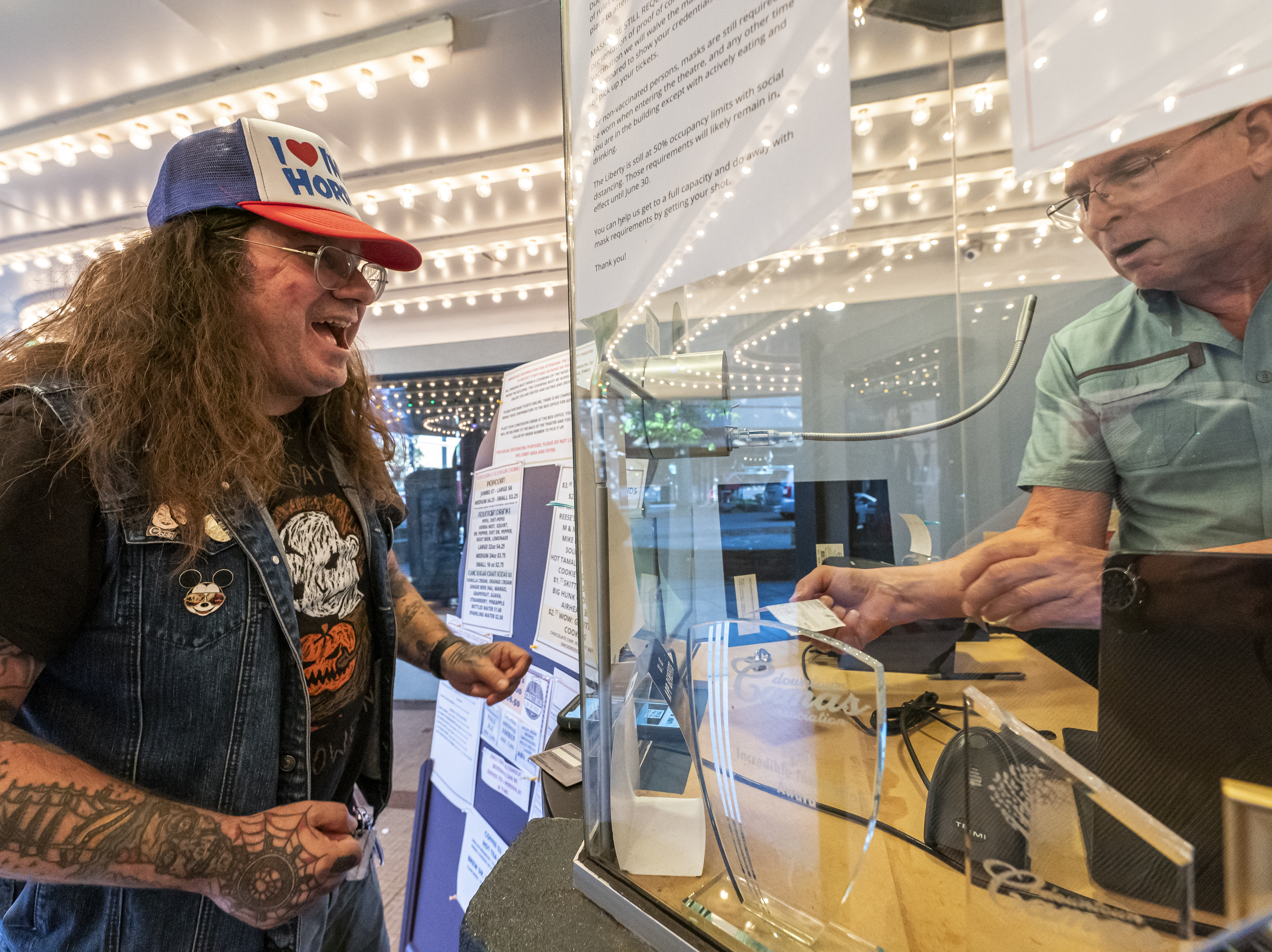 Darren Ford (left) reacts to the new mask guideline while presenting his vaccine card at Liberty Theatre on May 14 in Camas, Wash. Gov. Jay Inslee announced last Thursday that the statewide mask mandate would no longer apply to fully vaccinated adults. Nathan Howard/Getty Images