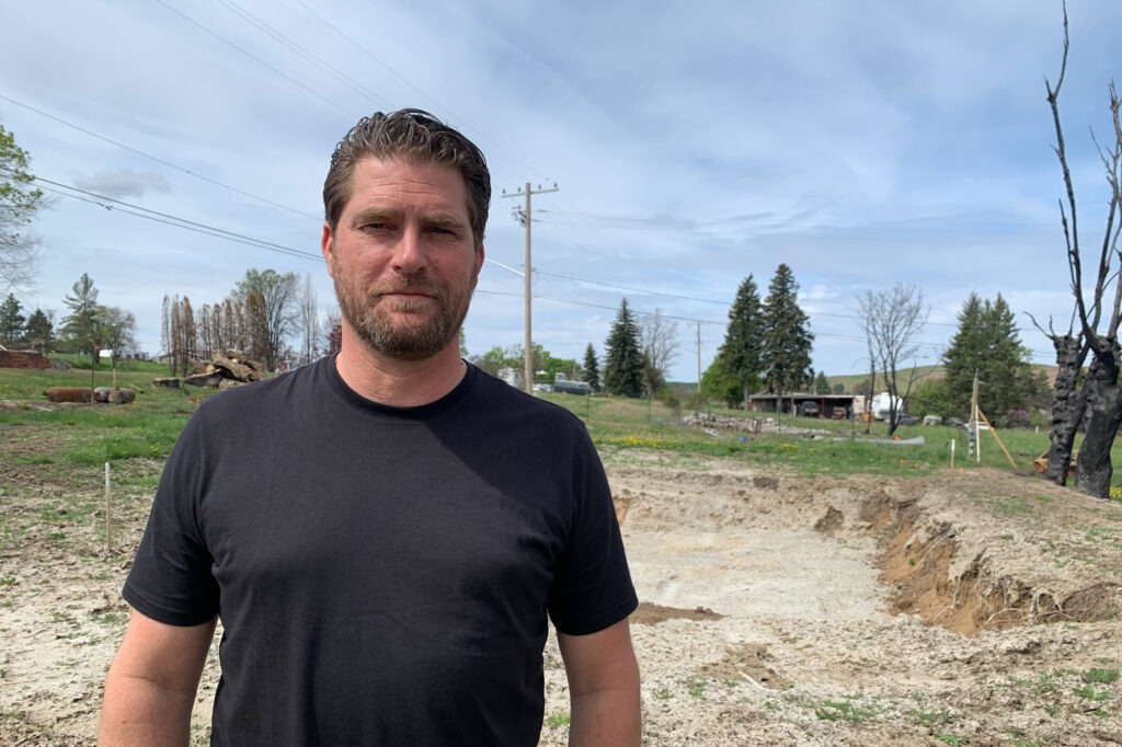 Scott Hokonson stands at the site of where his home used to be in Malden, Wash. A wildfire on Labor Day of 2020 destroyed 80% of the small farming town. CREDIT: Kirk Siegler/NPR